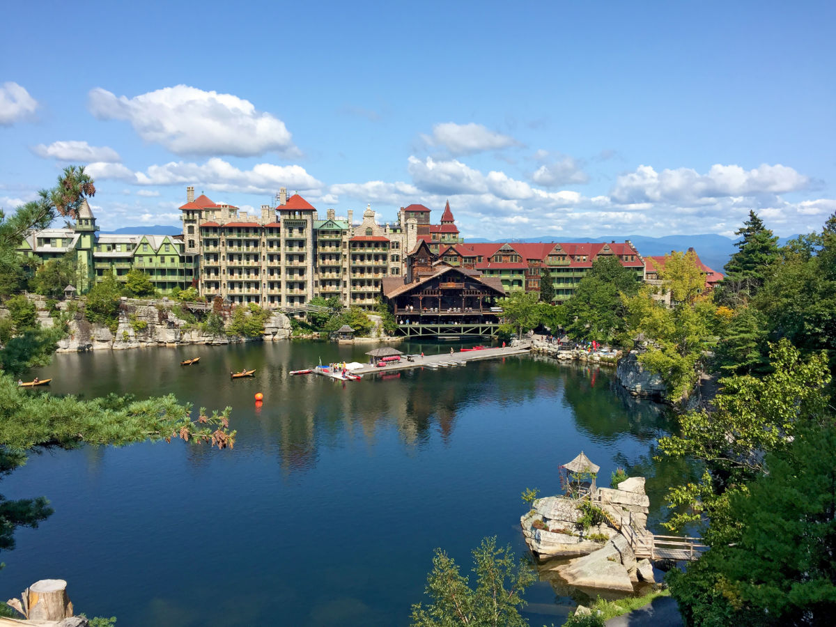Mohonk Mountain House across a lake with a dock and small rock island in New Paltz