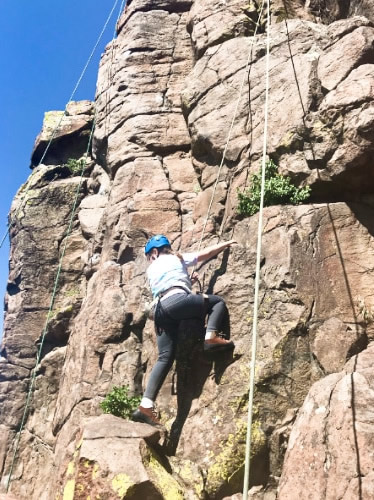 A woman rock climbing at the North Table Mountain on a sunny day