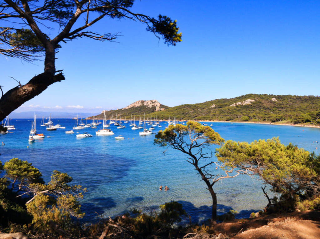 Overlooking view of the lush mountains and the boats sailing on the Notre Dame Beach