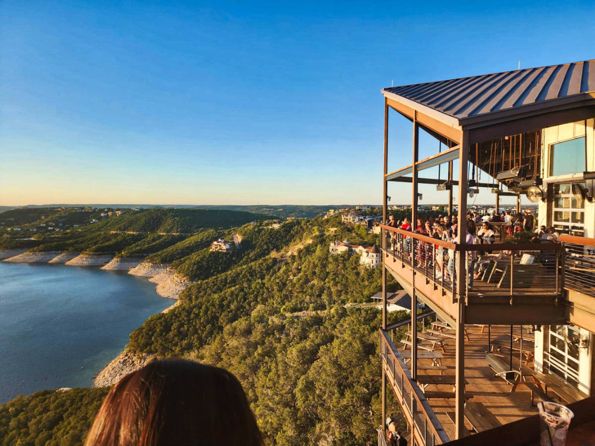 View of the crowd enjoying the overlooking view of Lake Travis from The Oasis at sunset