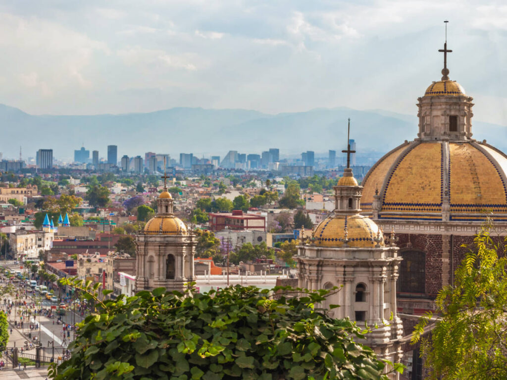 View of the roofs of The Old Basilica Guadalupe and the skyline of Mexico City