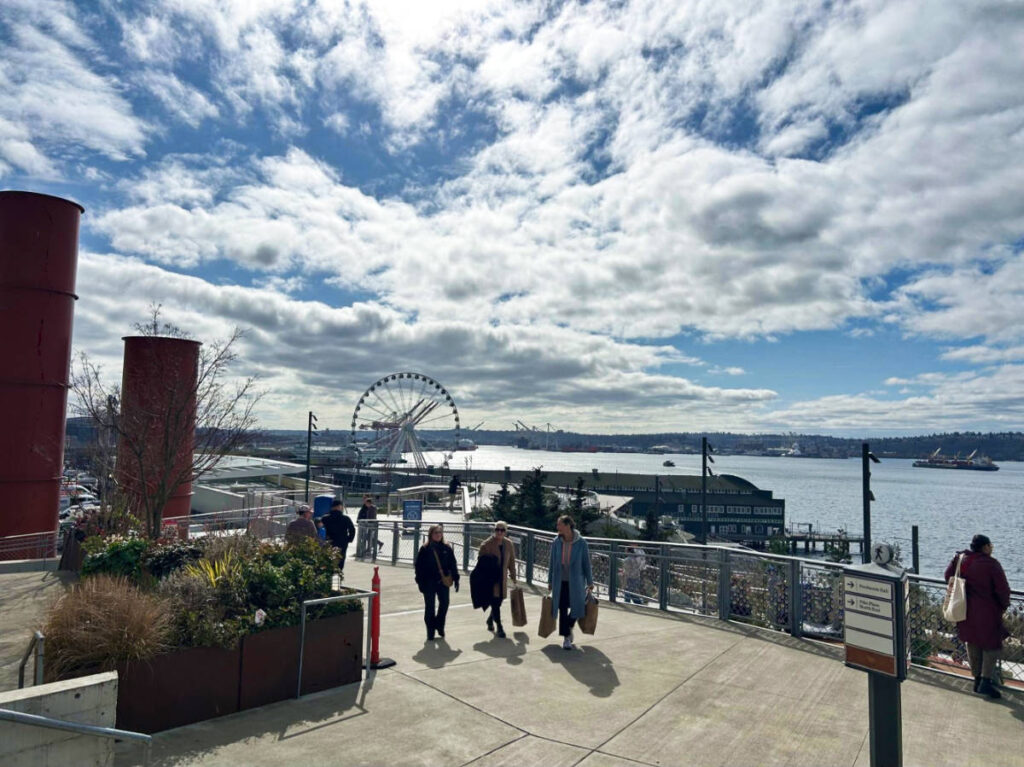 People wandering at The Overlook Walk with city skyline views