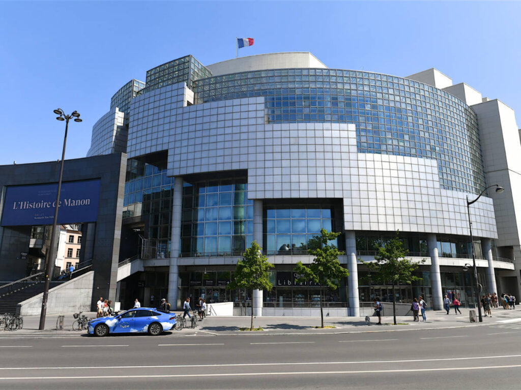 People passing in front of the modern building of the Paris Opera Bastille