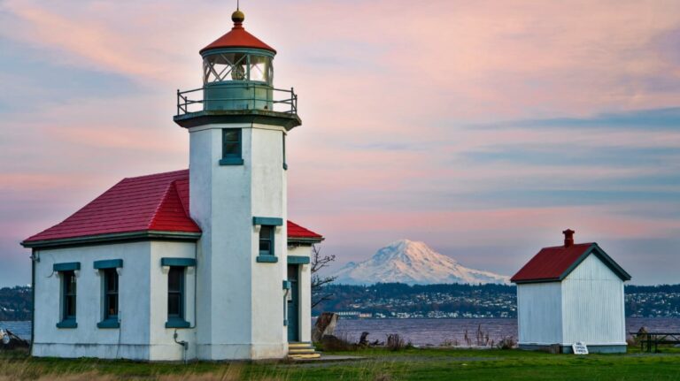 View of the exterior of Point Robinson Lighthouse with Mount Rainier in the background at sunset