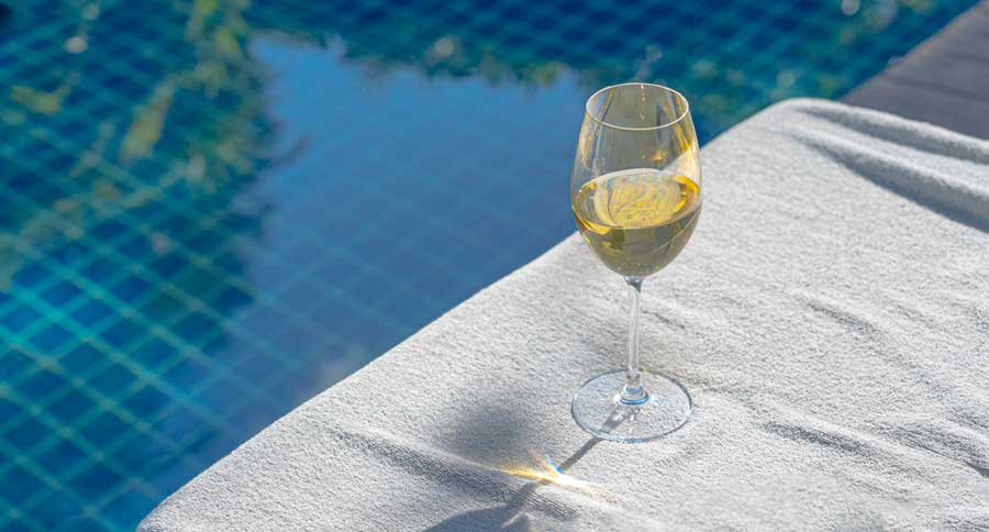 A glass of wine beside the pool area