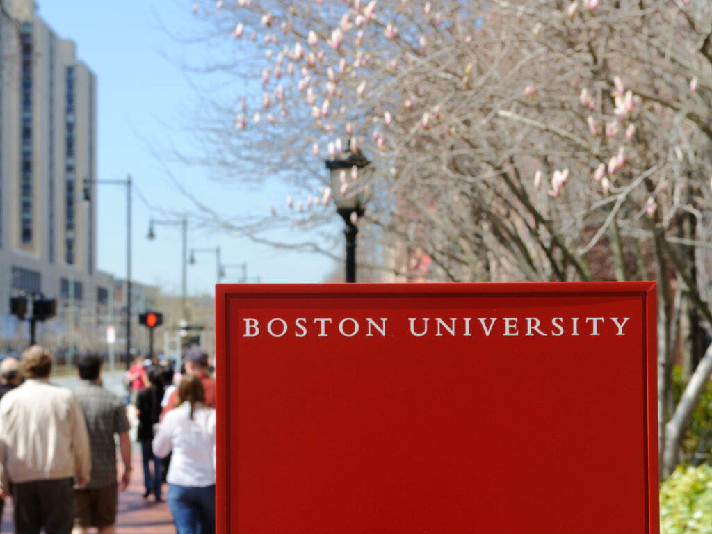 Boston University sign and crowd of students walking by in early spring
