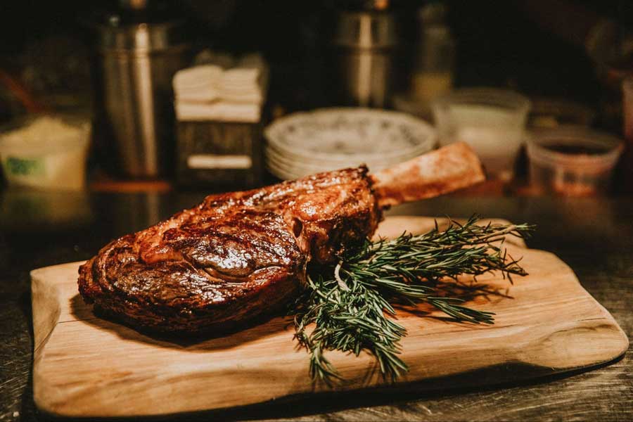 View of a steak on a wooden board in The Ravenous Pig