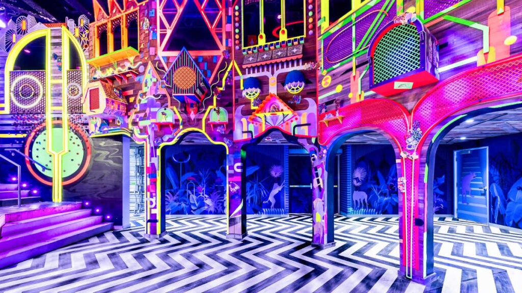 View of the illuminated neon lights and colorful interior designs of The Real Unreal in Grapevine