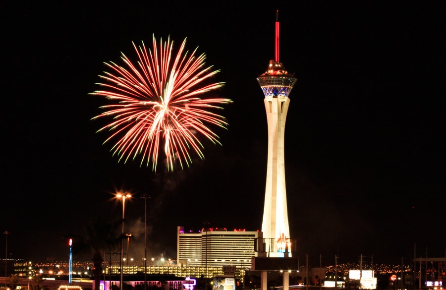 Night view of the STRAT tower and cityscape with a firework in the background