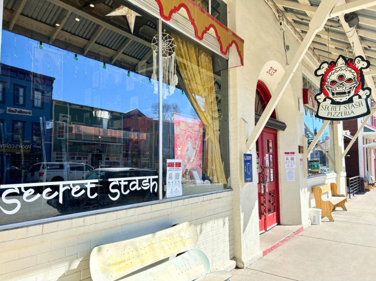 View of the front window, entrance door and signage outside The Secret Stash