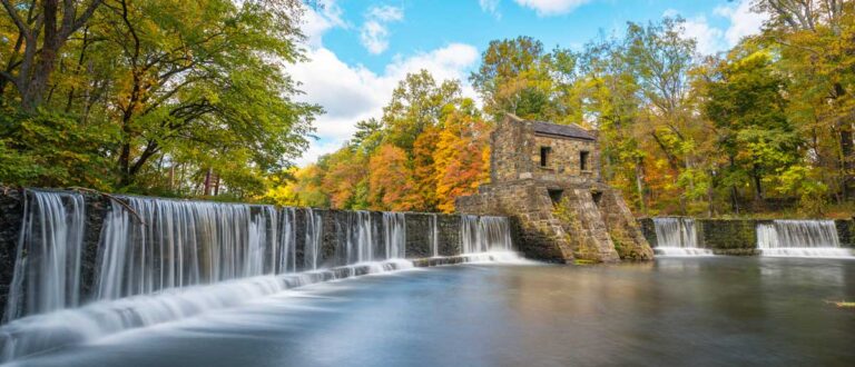A serene view of the Speedwell Dam Waterfall, surrounded by trees in the background