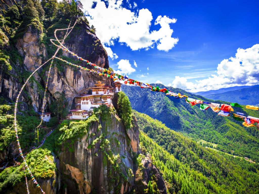 View of the buildings in the cliff and the colorful buntings in The Tiger’s Nest Monastery