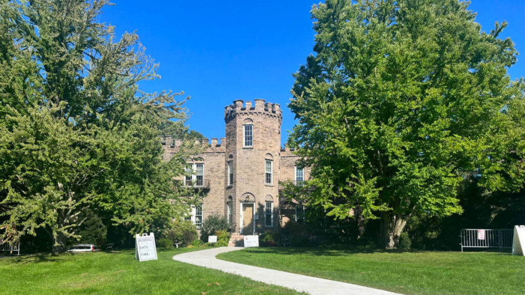 View of Warner Castle surrounded by lush green lawn and trees