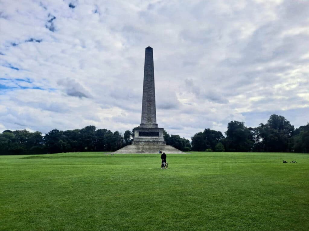 Panoramic view a biker in front of The Wellington Monument at the Phoenix Park