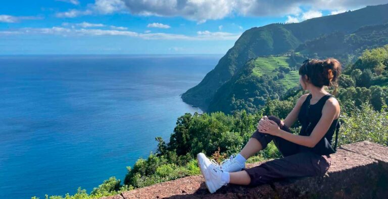 The author Lea Rose Allbaugh admiring a scenic ocean view in Sao Miguel Island, Portugal