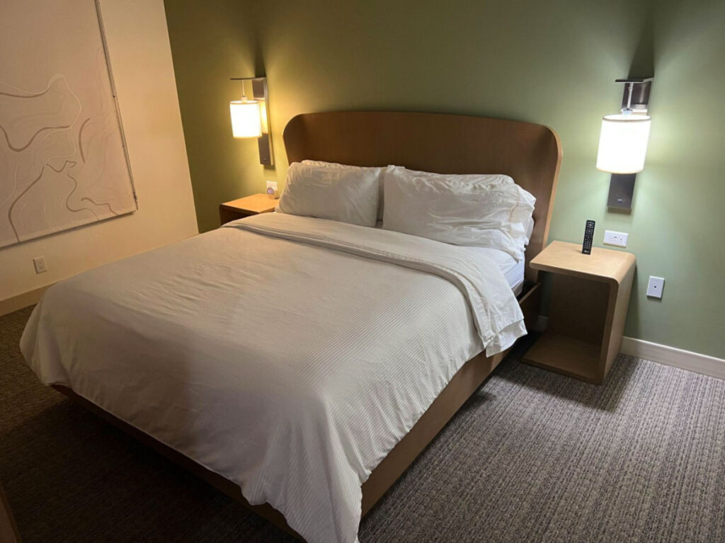 A room bed with white sheets and fluffy pillows at Element Denver Downtown East