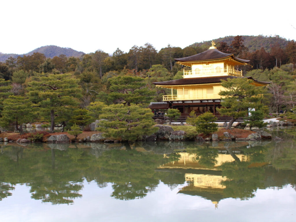 Golden Kinkaku-ji Temple in the middle of a lake, shining brightly in the Kita neighborhood