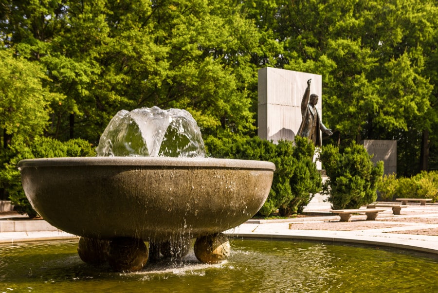 View of the Theodore Roosevelt Memorial and a fountain in the middle of a lush green area