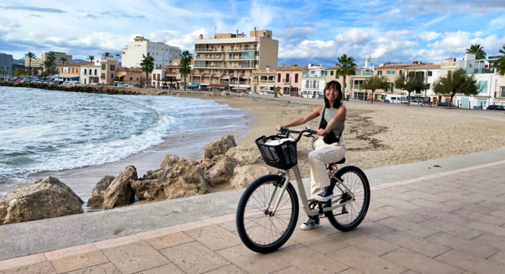 The author Lea Rose Allbaugh cycling around a local beach, one of the best things to do in Palma de Mallorca