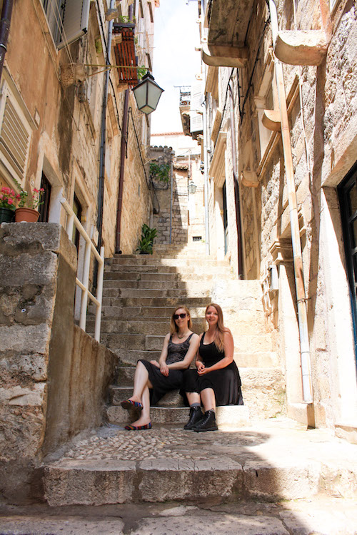 Taylor and a friend sit on steps in the old town of Dubrovnik