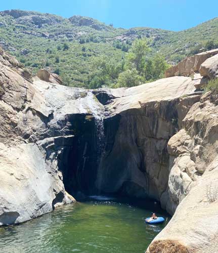 View of a woman having a swim in Three Sisters Falls
