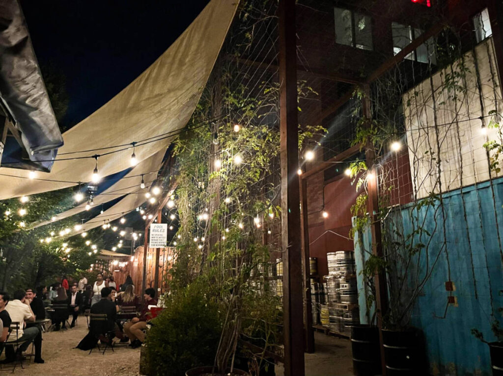 View of the people enjoying at the beer garden of Threes Brewing at night