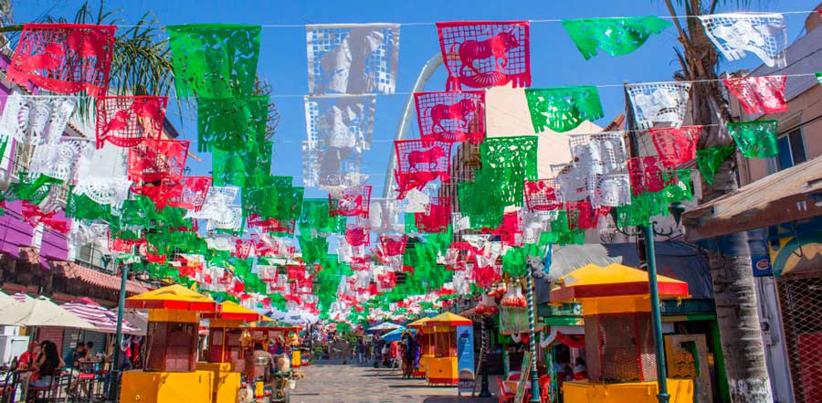 Colorful Mexican party decorations hanging on a street in Tijuana