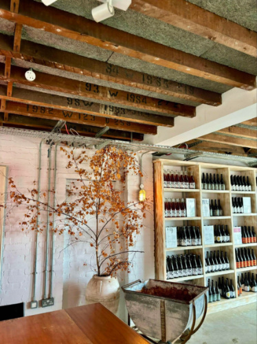 View of the wines on display and the rustic barnyard interiors of Tillingham Winery
