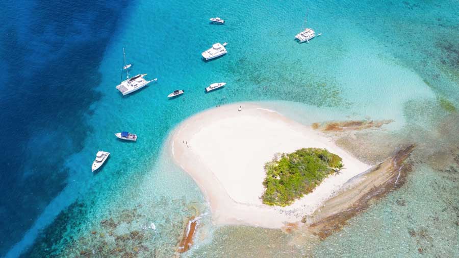 Aerial view of a tiny island and boats near Jost Van Dyke
