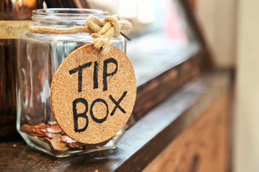 Coins inside a glass of tip box