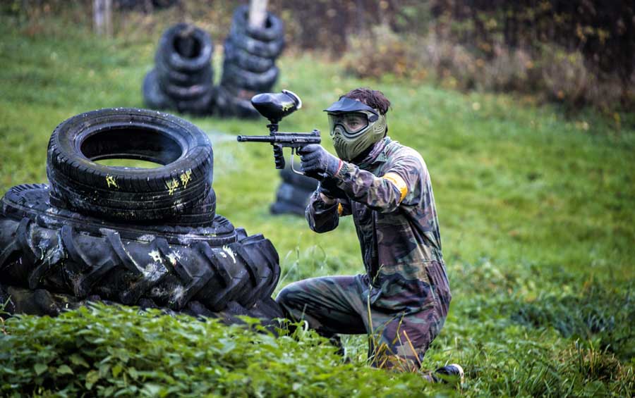 A paintball player aiming in Tito’s Paintball Park