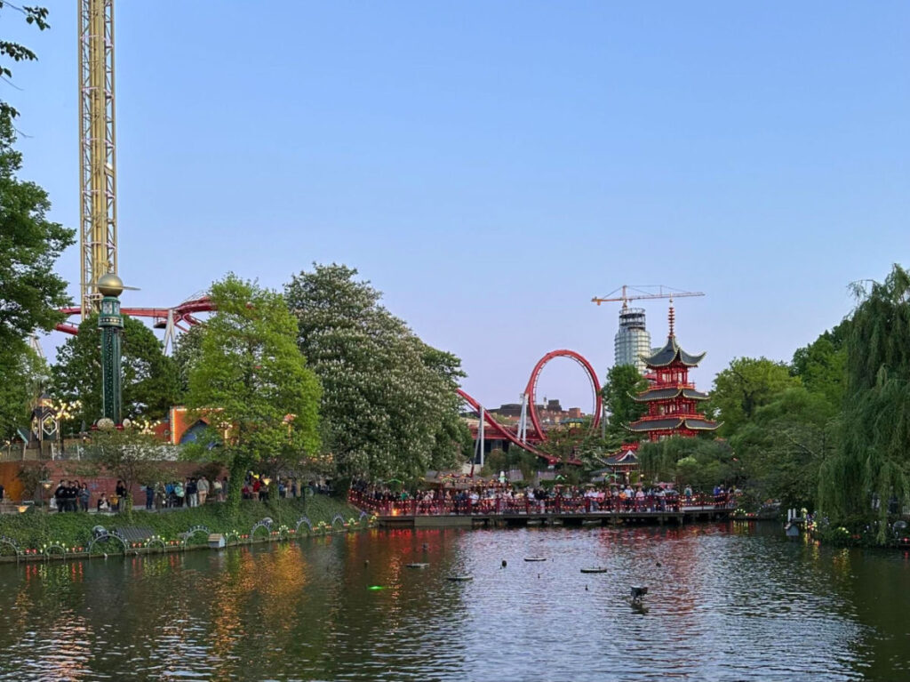 Tivoli Gardens featuring a serene lake and an roller coaster ride