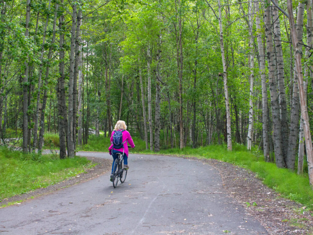 A woman biking at the Tony Knowles Coastal Trail during an early morning