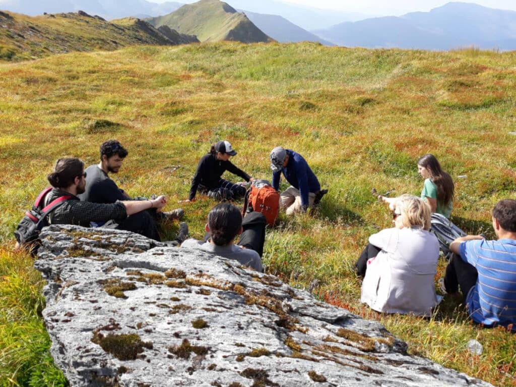 The author with his friends taking a break on top of a mountain in Alaska