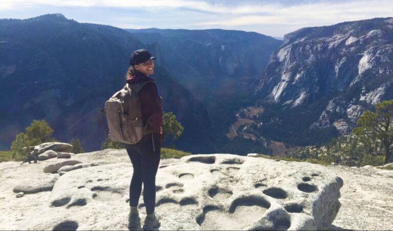 The author (McKenna Mobley) at the top of the North Dome hike with Yosemite Valley