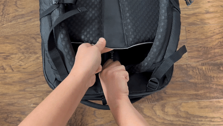 Abigail adjusting the back panel of the Tortuga Travel Backpack