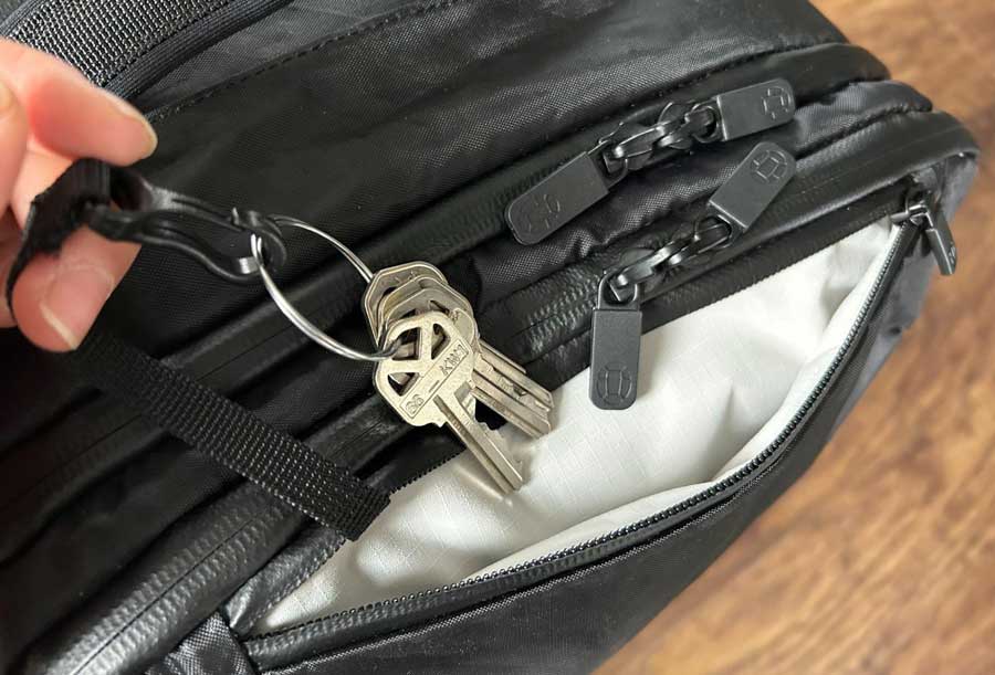 Close up view of the key clip of the Tortuga Travel Backpack with keys on it