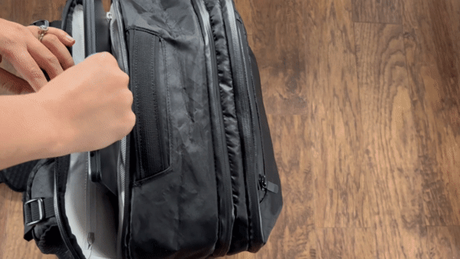 Abigail putting her laptop on the laptop sleeve of Tortuga Travel Backpack