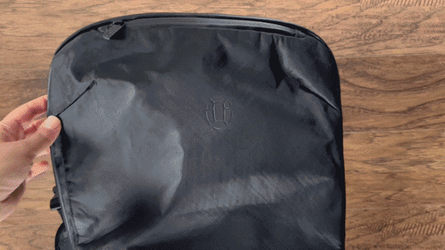 Abigail putting her passport on the mesh pocket of Tortuga Travel Backpack