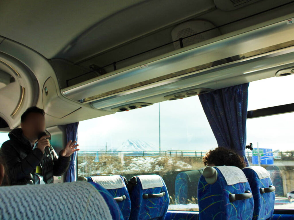 The tour guide speaking inside the bus