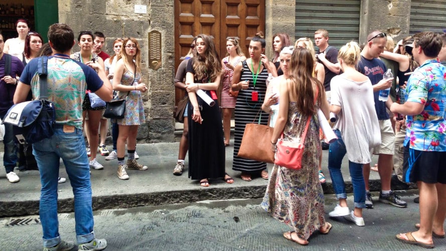 A tourist group with guide in the side of the street