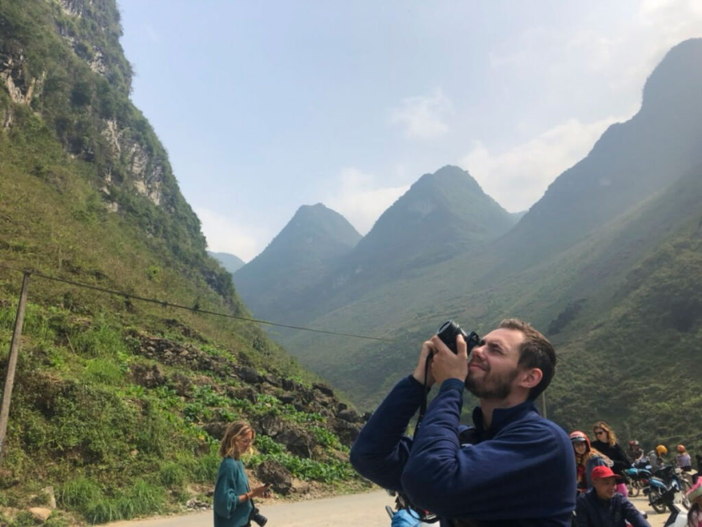 A man taking photos of the mountain in Ha Giang