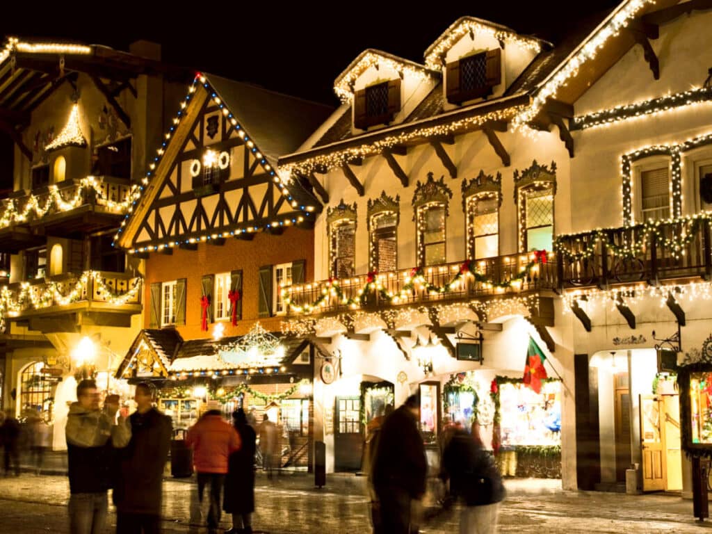 View of the tourists in front of the buildings decorated with Christmas lights