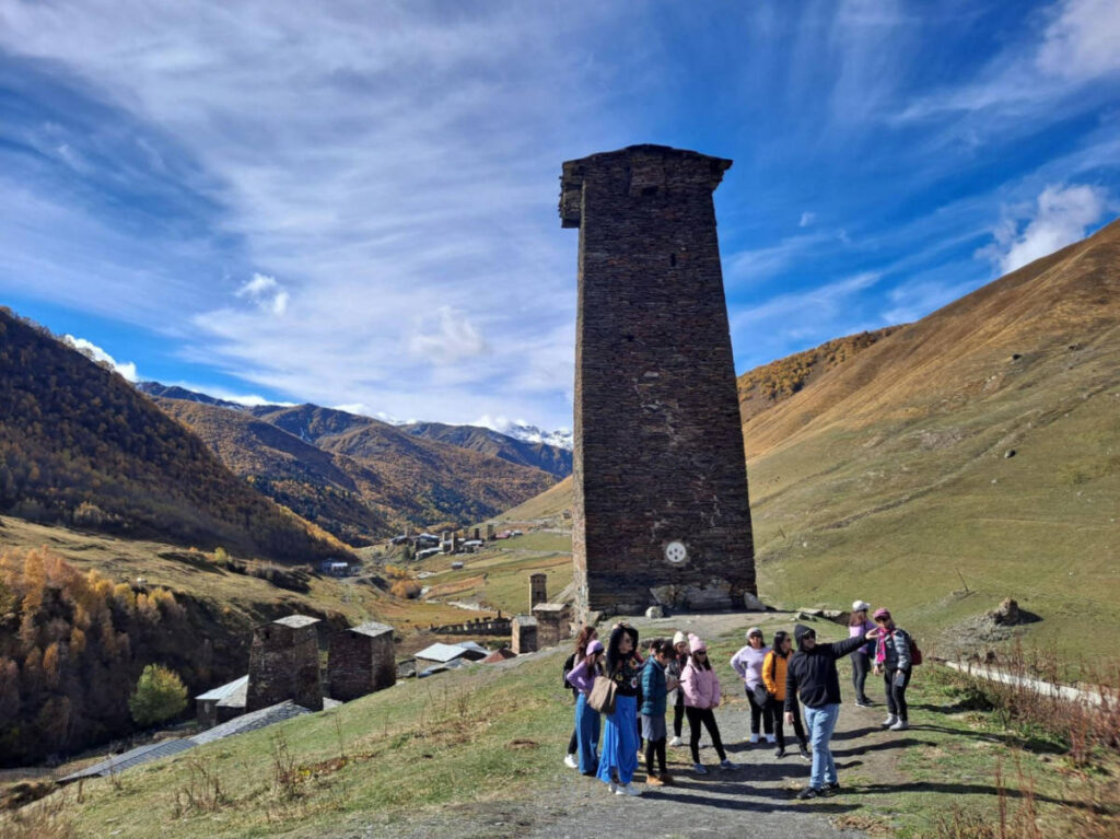 A group of tourists enjoying the mountains views at Mestia Watchtower