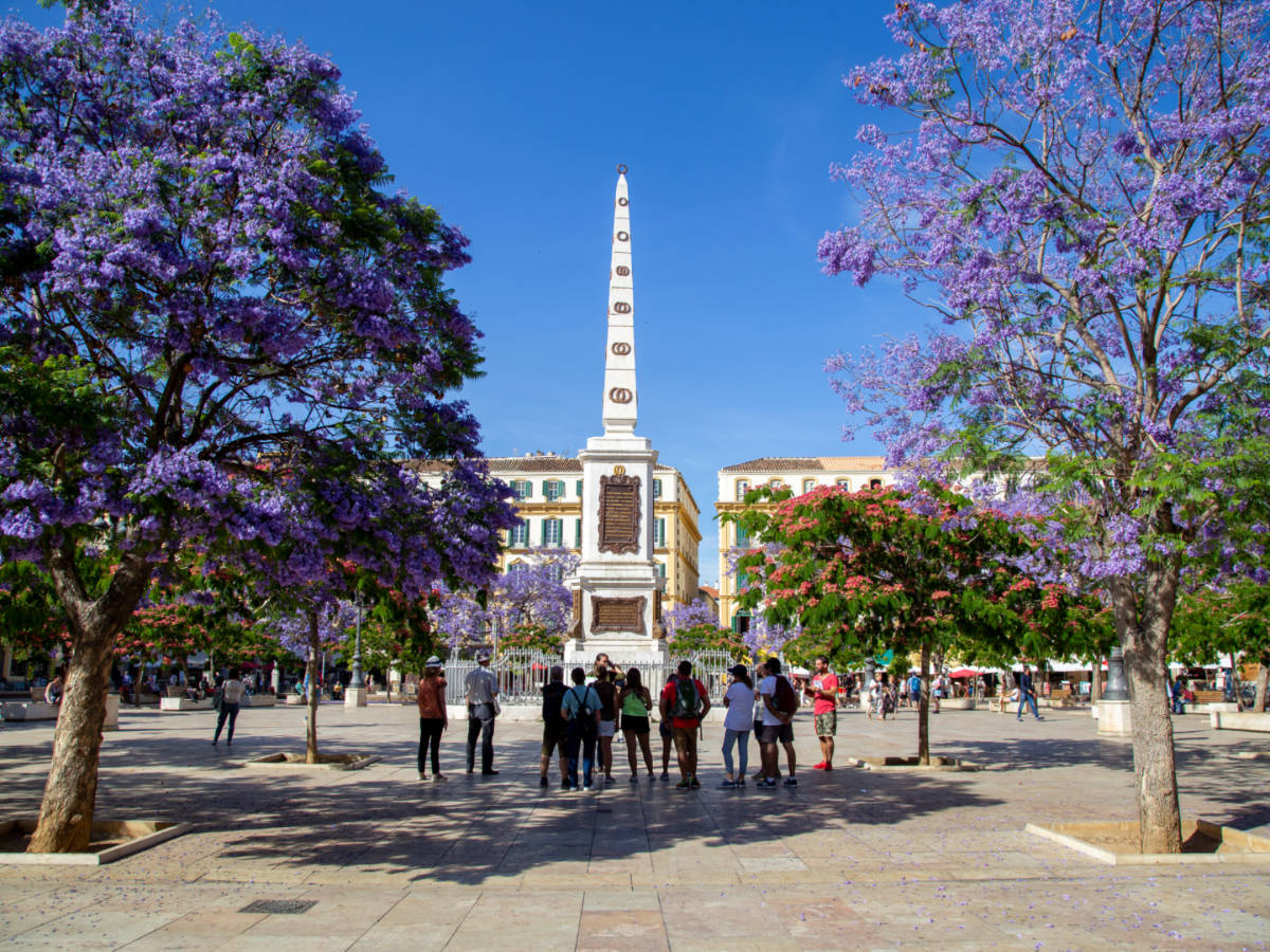 Tourists looking at the monument in the middle of the Plaza de La Merced