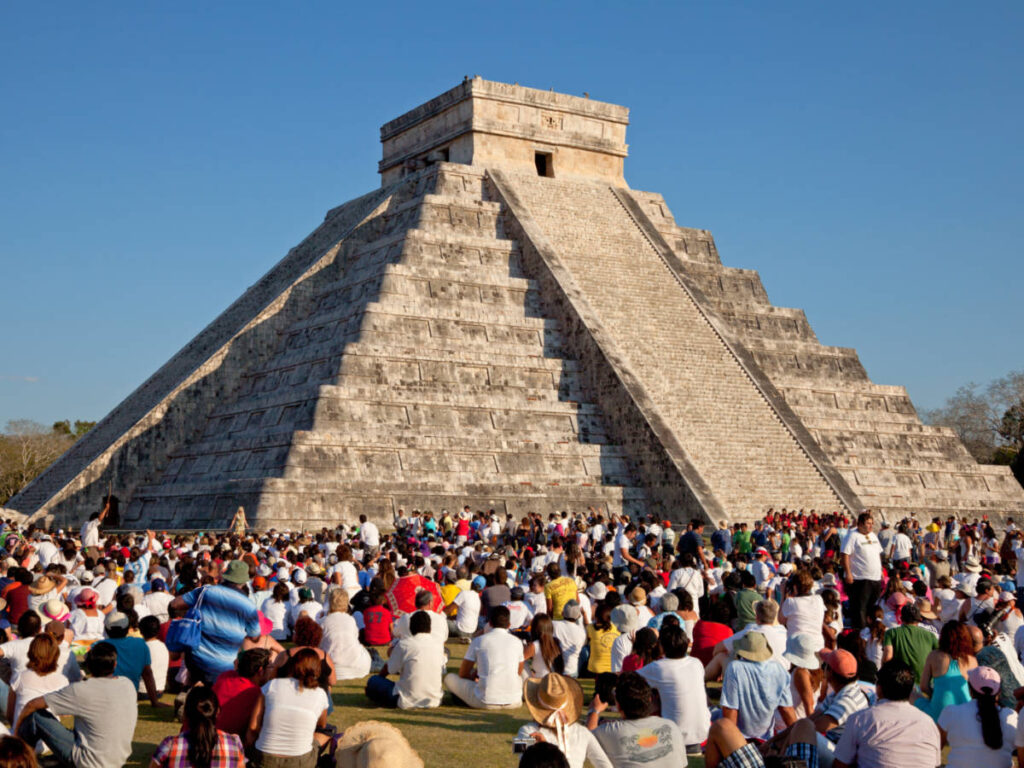 Tourists watching the feathered serpent crawling down the temple on Equinox in Chichen Itza, Mexico