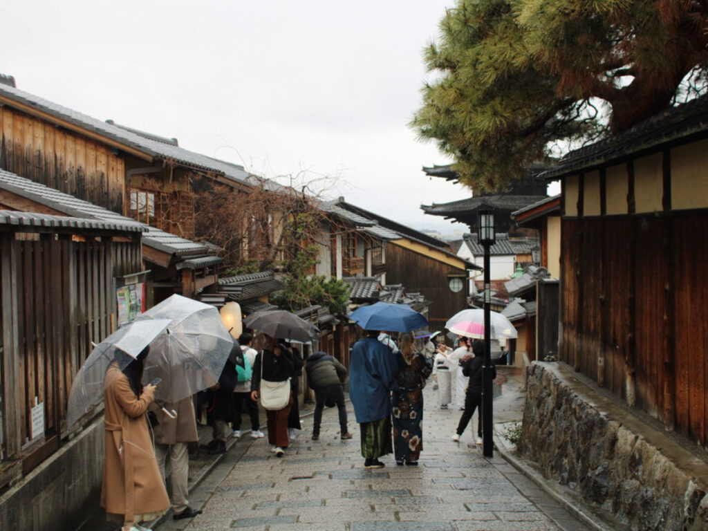 Tourists walking on a road in Gion on a rainy day