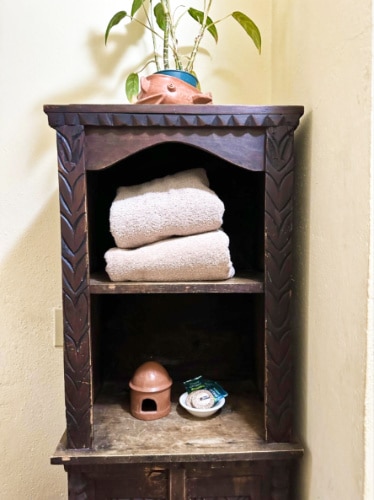A storage rack with toiletries and towels in La Casa del Mundo