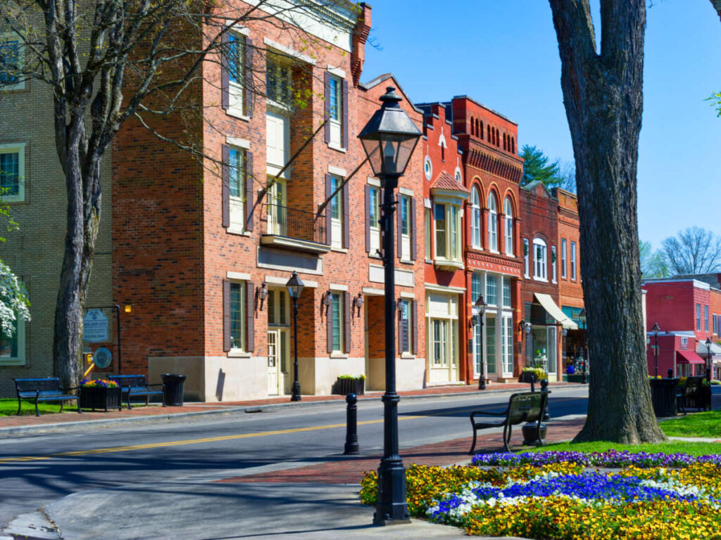 View of the peaceful street with brick walled buildings and blooming flowers around