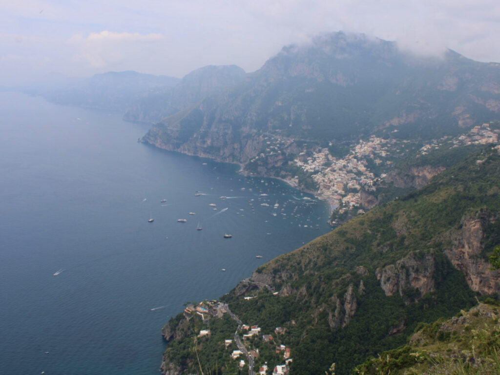 View of ocean and mountains from cliff overlooking town on Amalfi Coast hike